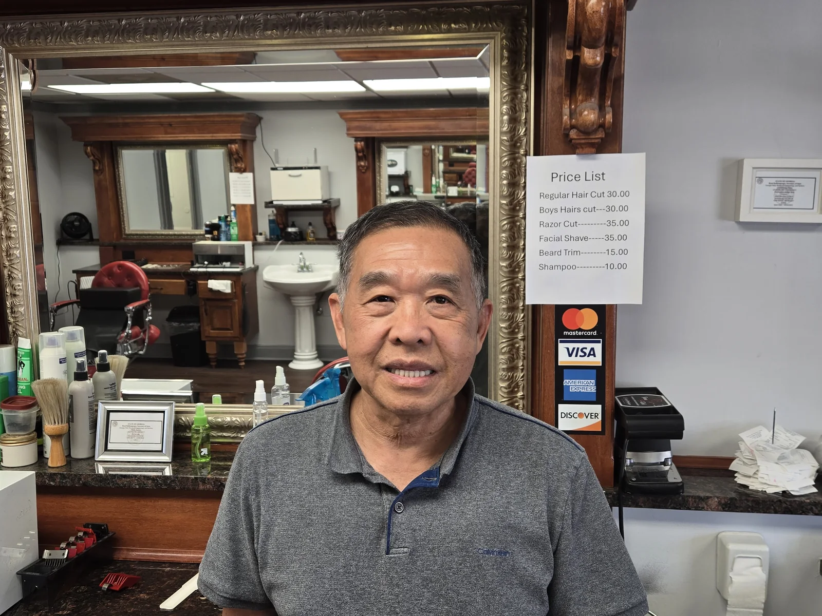 Kevin Lam, master barber and owner, inside Dunwoody Barber Shop